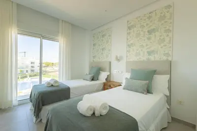 a bedroom with two beds and a window at Costa Ballena Deluxe Seafront by Valcambre in Cádiz