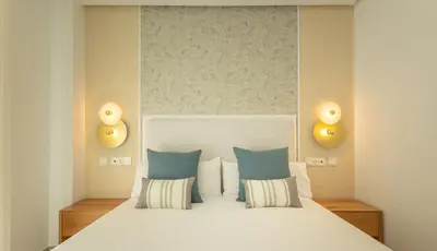 a bedroom with a large bed with blue pillows at Costa Ballena Deluxe Seafront by Valcambre in Cádiz