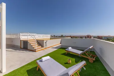 a balcony with green grass and stairs on a building at Costa Ballena Deluxe Seafront by Valcambre in Cádiz
