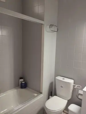 a white bathroom with a toilet and a bath tub at Piso IBERIAN PREMIUM in Sanlúcar de Barrameda