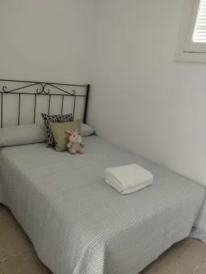 a bed with a teddy bear and a towel on it at Piso IBERIAN PREMIUM in Sanlúcar de Barrameda