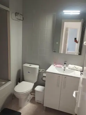 a white bathroom with a toilet and a sink at Piso IBERIAN PREMIUM in Sanlúcar de Barrameda