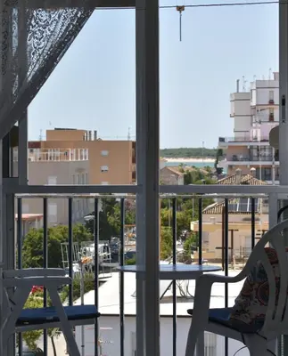 a balcony with chairs and a view of a city at Piso IBERIAN PREMIUM in Sanlúcar de Barrameda