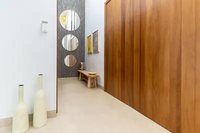 a hallway with two white vases and a wooden door at Villa Gatán in Chiclana de la Frontera