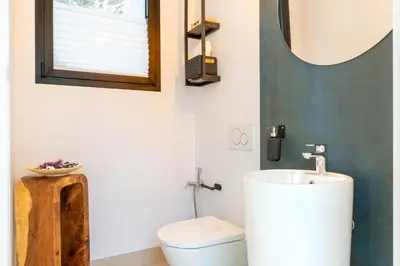 a bathroom with a toilet and a sink and a mirror at Villa Gatán in Chiclana de la Frontera