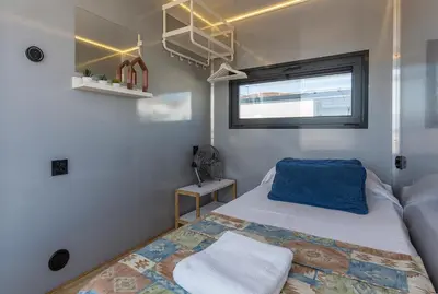 a small bedroom with a bed and a window at Azvalia Luxury Casa Barco New York and Texas-Unique Houseboat Experience in El Puerto de Santa María