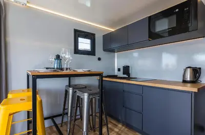 a kitchen with blue cabinets and bar stools at Azvalia Luxury Casa Barco New York and Texas-Unique Houseboat Experience in El Puerto de Santa María