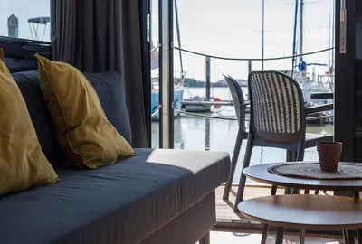 a living room with a couch and a table and chairs at Azvalia Luxury Casa Barco New York and Texas-Unique Houseboat Experience in El Puerto de Santa María