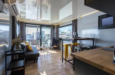 a kitchen and living room with a couch and a table at Azvalia Luxury Casa Barco New York and Texas-Unique Houseboat Experience in El Puerto de Santa María
