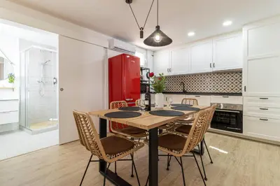 a kitchen with a table with chairs and a red refrigerator at AdEva Céntrico 3 Habitaciones in Jerez de la Frontera