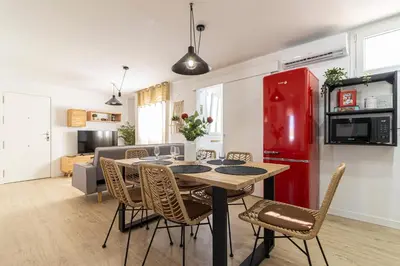 a kitchen and dining room with a table and a red refrigerator at AdEva Céntrico 3 Habitaciones in Jerez de la Frontera