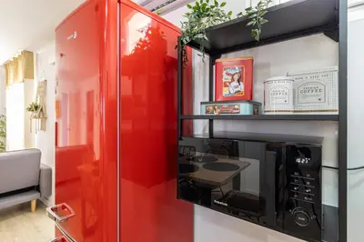 a red and black microwave oven in a room at AdEva Céntrico 3 Habitaciones in Jerez de la Frontera