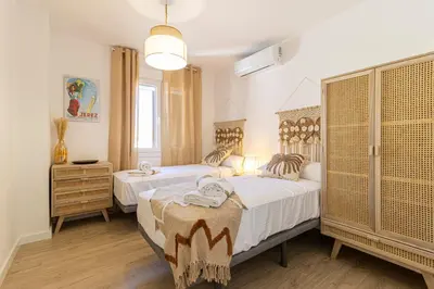 a bedroom with two beds and a dresser at AdEva Céntrico 3 Habitaciones in Jerez de la Frontera