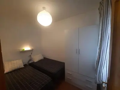 a small bedroom with a bed and a light at apartamento Atlanta in Chipiona
