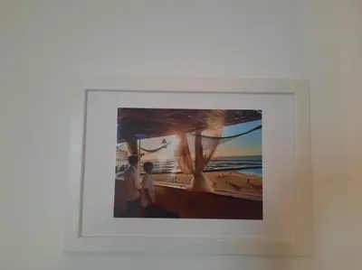 a framed picture of two people on the beach at apartamento Atlanta in Chipiona
