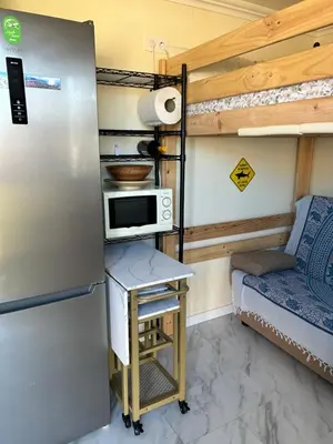 a kitchen with a refrigerator and a table with a microwave at Lugar acogedor al lado de La Barrosa in Campano