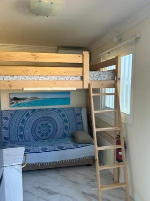 a bunk bed in a tiny house with a ladder at Lugar acogedor al lado de La Barrosa in Campano