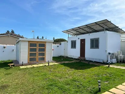 a small white house with a roof at Lugar acogedor al lado de La Barrosa in Campano