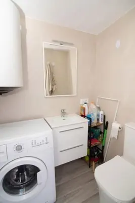 a bathroom with a washing machine and a sink at Pipoca's Beach in Novo Sancti Petri
