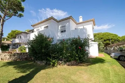 a white house with a bush in front of it at Pipoca's Beach in Novo Sancti Petri