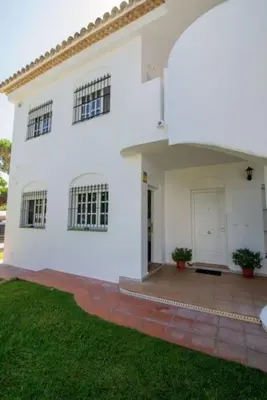 a white house with a porch and a yard at Pipoca's Beach in Novo Sancti Petri