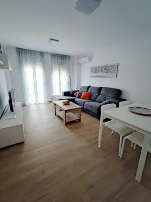 a living room with a blue couch and a table at Apto 5 personas con todo equipado in San Fernando