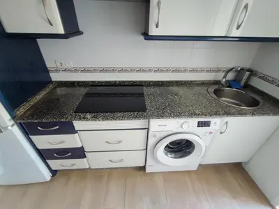 a small kitchen with a washing machine and a sink at Apto 5 personas con todo equipado in San Fernando