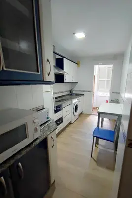 a kitchen with a table and a microwave at Apto 5 personas con todo equipado in San Fernando