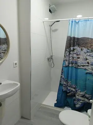a bathroom with a shower curtain with a boat on it at La Finquita in Chiclana de la Frontera