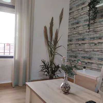 a vase with flowers on a table in a room at Apartamento ESPERANZA DE LA YEDRA in Jerez de la Frontera