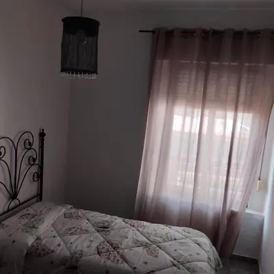 a bedroom with a bed and a window with curtains at Apartamento ESPERANZA DE LA YEDRA in Jerez de la Frontera