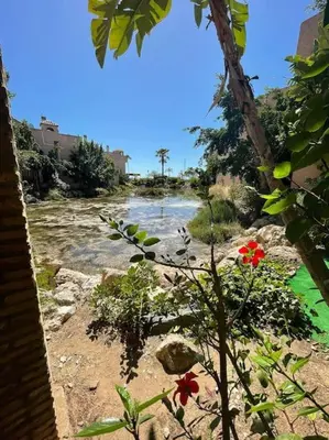 a house and a river in front of a building at Magnifico Bungalow 2 plantas 110 m,con 3 piscinas in San Fernando
