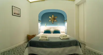 a bedroom with a large bed with a blue headboard at T&S La Bóveda in Arcos de la Frontera