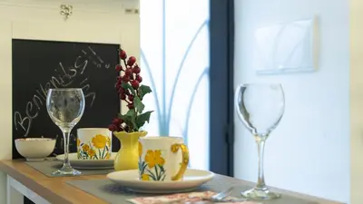 a table with two wine glasses and a vase at T&S La Bóveda in Arcos de la Frontera