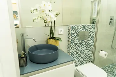 a bathroom with a blue sink and a vase of flowers at T&S La Bóveda in Arcos de la Frontera