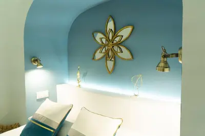 a bedroom with a blue wall with a flower on it at T&S La Bóveda in Arcos de la Frontera