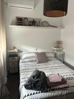 a dog laying on a bed in a bedroom at Piso Acogedor en pleno centro in El Puerto de Santa María
