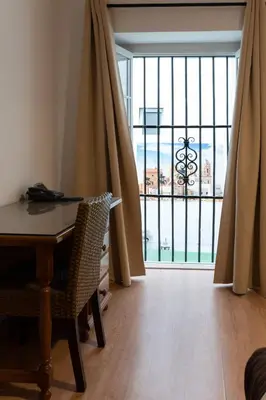 a dining room with a table and a large window at Hotel Alquimia Cadiz in Cádiz