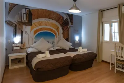 a bedroom with a large bed in a room with an arch at Hotel Alquimia Cadiz in Cádiz