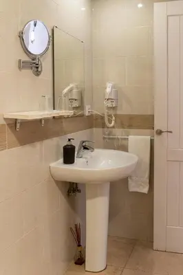 a white bathroom with a sink and a mirror at Hotel Alquimia Cadiz in Cádiz