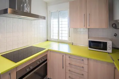 a kitchen with a yellow counter top and a microwave at Apartamentos El Ático de Hércules in Cádiz