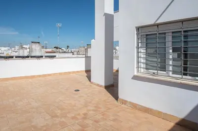 a balcony of a white building with a window at Apartamentos El Ático de Hércules in Cádiz