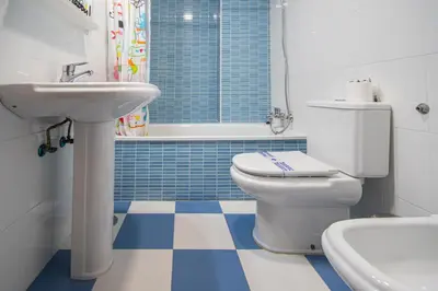 a bathroom with a toilet and a sink at Apartamentos El Ático de Hércules in Cádiz