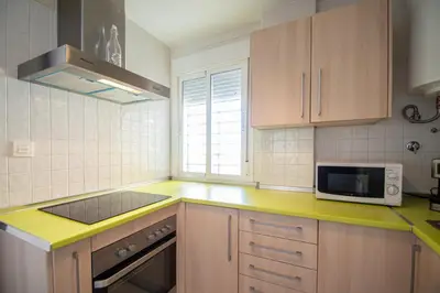 a kitchen with a yellow counter top and a microwave at Apartamentos El Ático de Hércules in Cádiz