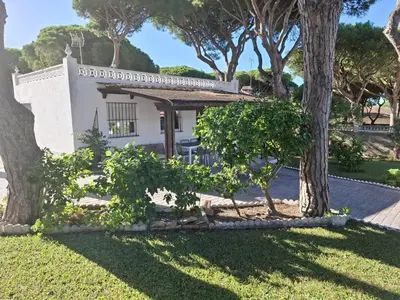 a small white house with trees in the yard at Ugaldenea- Playa in Chiclana de la Frontera