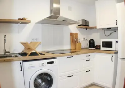 a kitchen with a washing machine and a sink at Ugaldenea- Playa in Chiclana de la Frontera