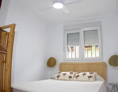 a bedroom with a bed and a window at Ugaldenea- Playa in Chiclana de la Frontera