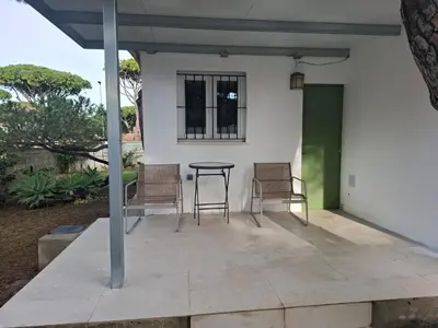 a patio with chairs and a table and a window at Ugaldenea- Playa in Chiclana de la Frontera