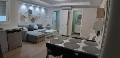 a kitchen and living room with a table and a couch at Piso del centro in Sanlúcar de Barrameda