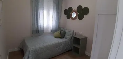 a bedroom with a bed and a mirror on the wall at Piso del centro in Sanlúcar de Barrameda